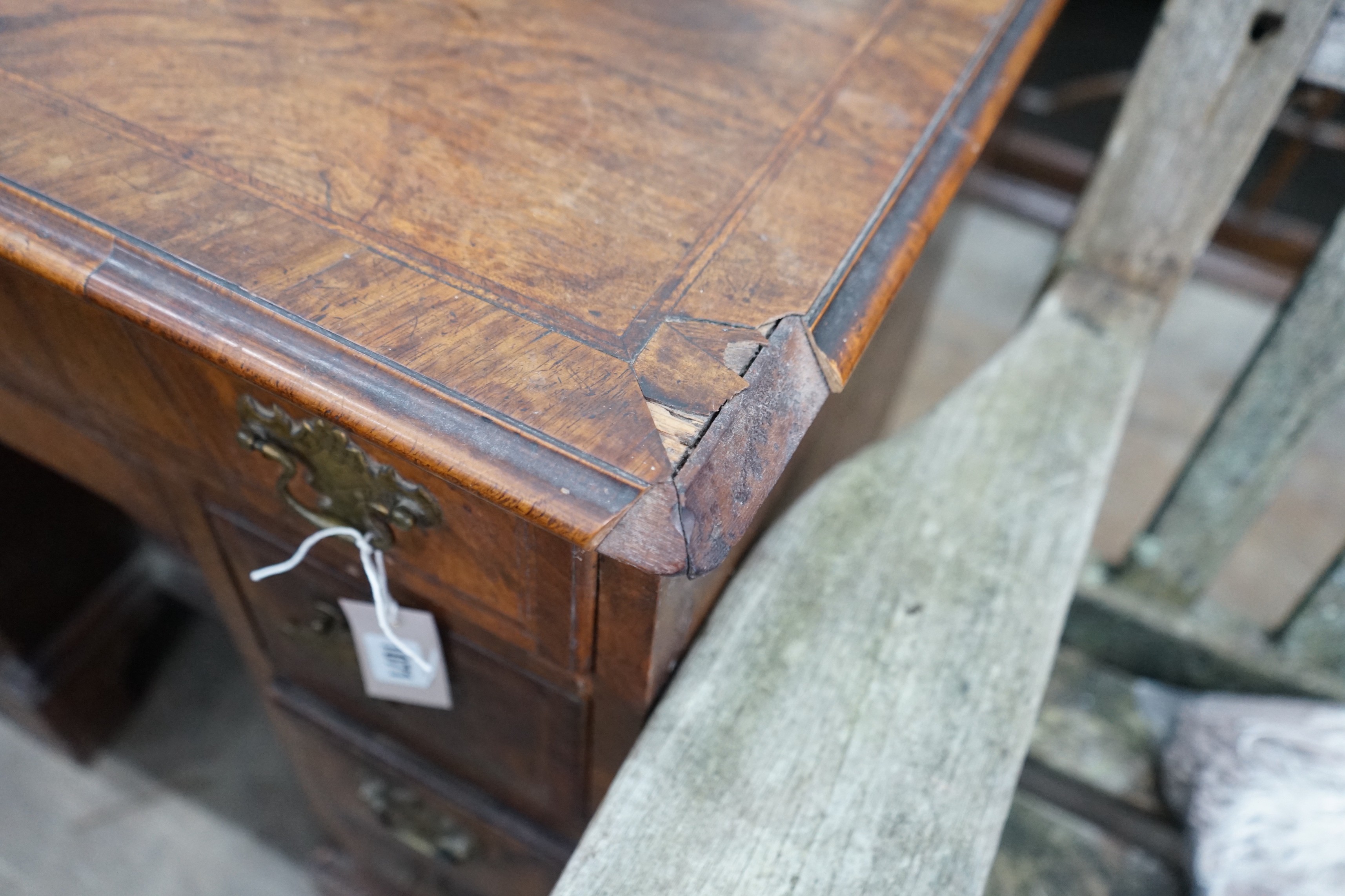 An 18th century feather banded walnut kneehole desk, width 81cms, depth 52cms, height 76cms.